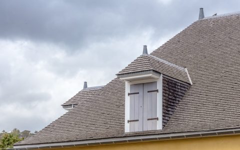 Toiture en bardeaux de maison coloniale avec fenêtres en chien assis